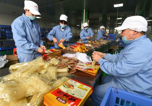 3月11日,在广西螺霸王食品包装车间内,工人在包装可速食的预